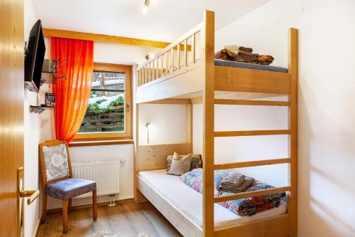 Una pequeña habitación con una litera y una escalera. en Hotel Sonnblick - Wohnung Klaus, en Kartitsch