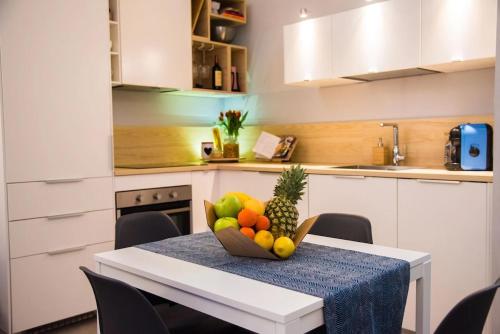 a kitchen with a table with a bowl of fruit on it at Luxury Boutique Apartment Milan in Milan