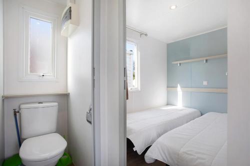 a small bathroom with two beds and a toilet at Bungalow T2 I V- 15 Min From Nazaré in Pataias