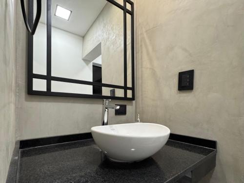 Un baño con un lavabo blanco sobre una encimera. en 250 Deptos Temporarios, en San Fernando del Valle de Catamarca