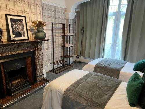 a hotel room with two beds and a fireplace at Spacious 7-Bedroom Victorian House in Darlaston