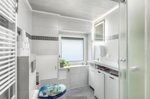 Bad EndbachFerienwohnung Klein Frankreich的带窗户和水槽的白色浴室