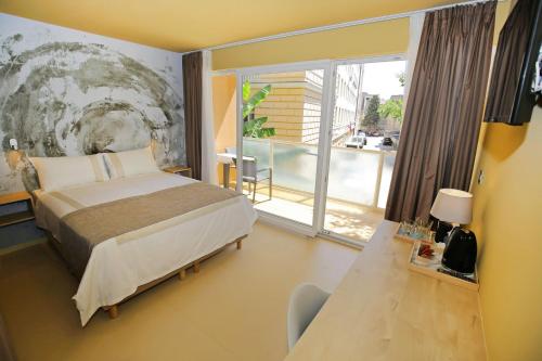 a hotel room with a bed and a balcony at Kai Boutique Studio & Rooms in Zadar