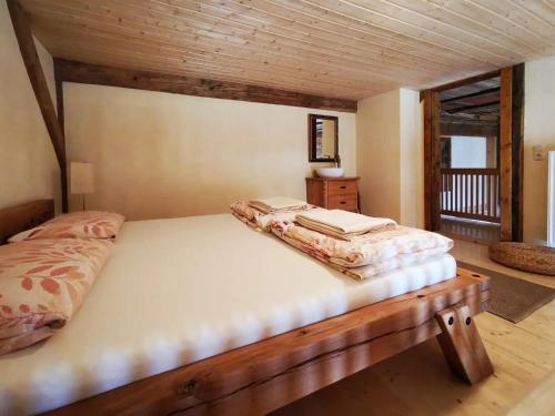a large bed in a room with a wooden ceiling at Ferienwohnung Galerie in Bad Schandau