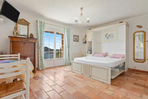 a bedroom with a large white bed with pink pillows at Studio Palmeraie in Saint-Raphaël
