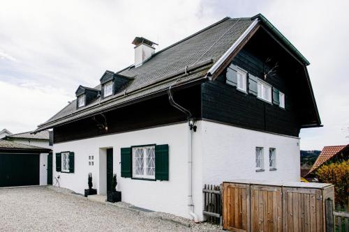 a white and black house with a black roof at Cottage Salzburg in Nußdorf am Haunsberg