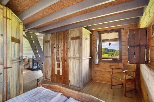 Un dormitorio con una cama y una ventana y una silla. en Hof Keppel, der stromlose Urlaub, en Schmallenberg