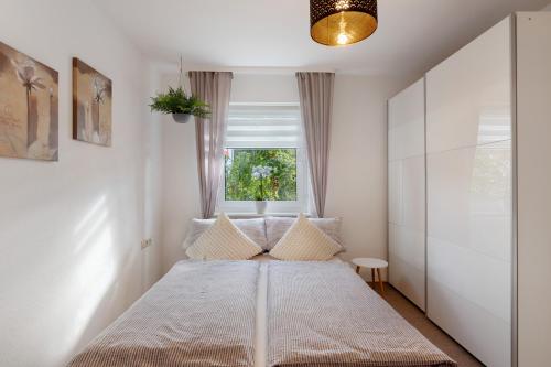 een slaapkamer met een bed en een raam bij Ferienwohnung Herzlicht in Titisee-Neustadt