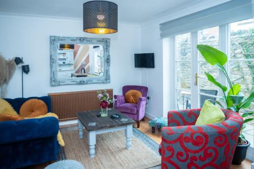 a living room with two chairs and a table at Avalon Sunrise our enchanting Glastonbury cottage in Glastonbury
