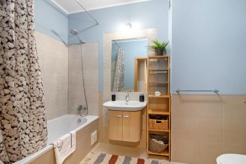 a bathroom with a tub and a sink and a bath tub at Apartamento Royal Cabanas Golf in Conceição