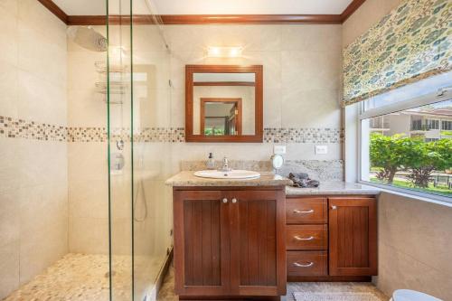 a bathroom with a sink and a glass shower at Beautiful Beachfront 2br Condo, With Full Kitchen in Tamarindo