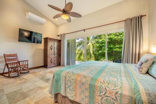 a bedroom with a bed and a large window at Beautiful Beachfront 2br Condo, With Full Kitchen in Tamarindo