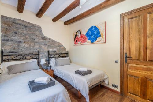 two beds in a room with a stone wall at Casa Pirinea in Belsierre
