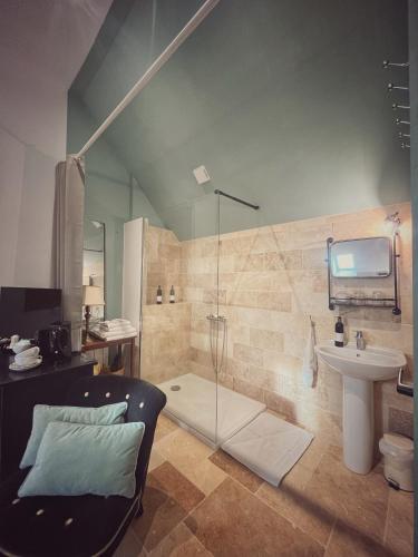 a bathroom with a glass shower and a sink at La Maison d'Horbé in La Perrière
