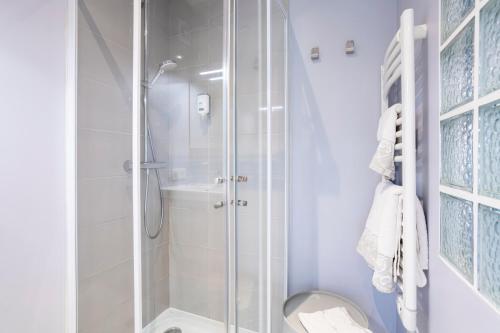 a white bathroom with a shower and a toilet at Studio avec terrasse au calme in Concarneau
