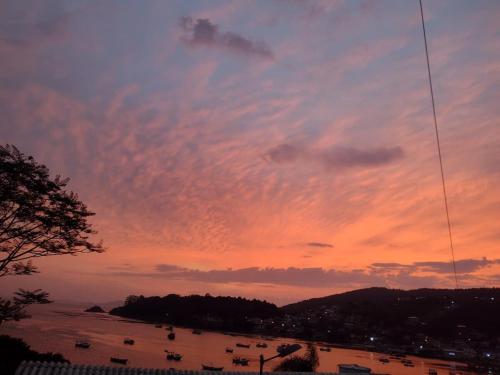 a sunset over a body of water with a sky at Casa Sol e Mar in Governador Celso Ramos