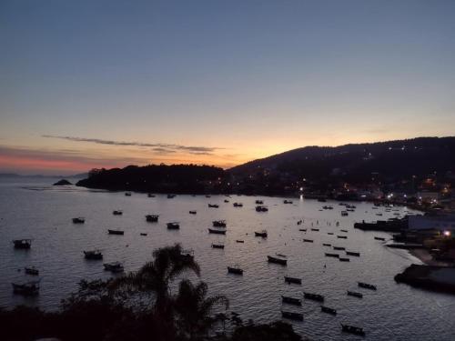 a group of boats in the water at sunset at Casa Sol e Mar in Governador Celso Ramos