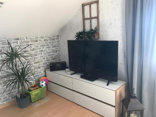 a television on a white dresser in a living room at Fewowe Ferienwohnung Wenden in Wenden