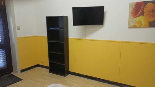 Una habitación con un televisor de pantalla plana en una pared. en Alabostreet51, en Augusta