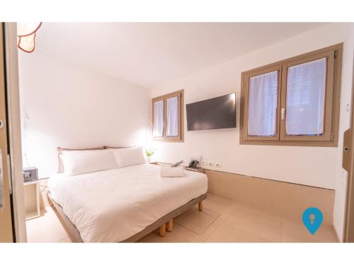 a bedroom with a white bed with a blue arrow at TriplyRooms Collection - Venezia in Venice