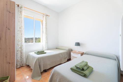 a bedroom with two beds and a window at Antiga escola Pla del Sabater in Culla