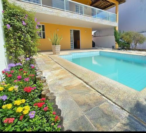 una piscina frente a una casa con flores en Hostel beach, en Aracaju