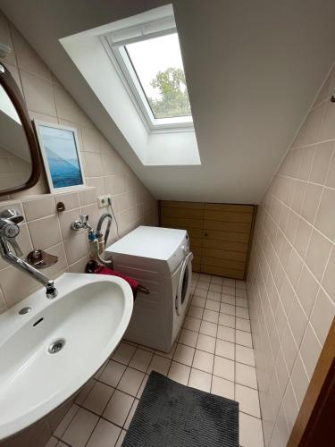 a bathroom with a sink and a window at Gemütliche Dachgeschoss Wohnung in Selm