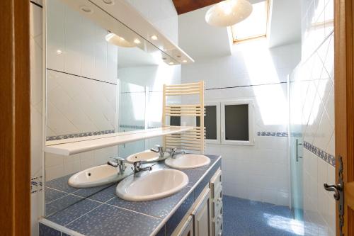 a bathroom with two sinks and a mirror at Le Calmadou in Formiguères