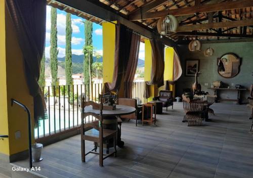a room with chairs and tables and a large window at Hotel e Pousada Ciconha-são Lourenço MG in São Lourenço