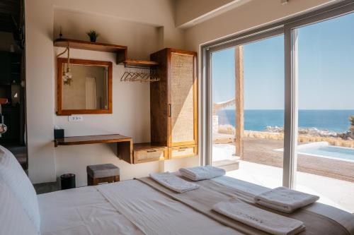a bedroom with a bed and a view of the ocean at Ammoo in Amoopi