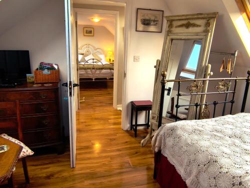 a bedroom with a bed and a dresser and a mirror at Castle View Suite - Corvesgate Cottage - 3 room suite in Corfe Castle