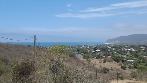 a town on a hill with the ocean in the background at Le jardin in Puerto López