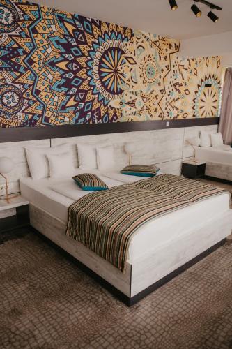 a bedroom with a large bed and a painting on the wall at Hotel Koncept Residence in Sarajevo