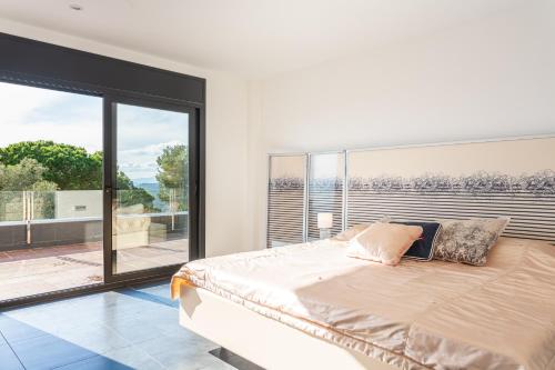 une chambre avec un grand lit et une grande fenêtre dans l'établissement Villa Roman, à Lloret de Mar