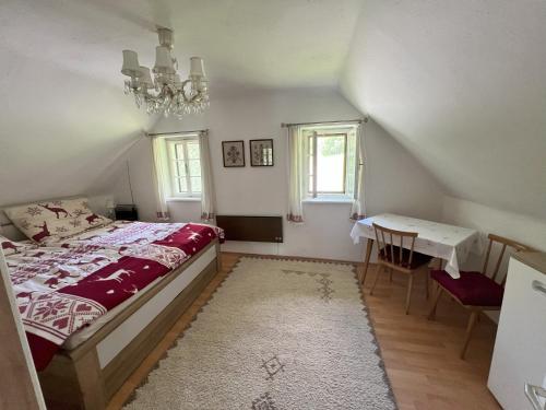 a bedroom with a bed and a table and a chandelier at Ferienhaus Maierhofer in Fischbach