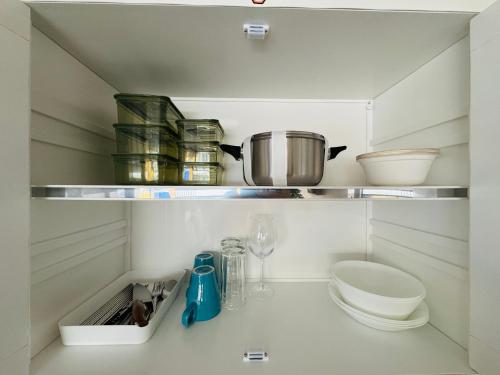 una cocina con un estante con una olla y otros utensilios de cocina en IMPACT challenger ห้องพักรายวัน เมืองทองธานี ตึก C9, P2, P1 每日房, en Nonthaburi