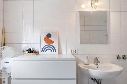 Un baño blanco con lavabo y espejo. en Ferienwohnung Feierabend, en Vogtsburg
