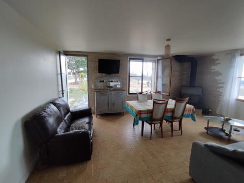 un salon avec un canapé, une table et des chaises dans l'établissement Chez Monique et Dédé, à Ferrassières