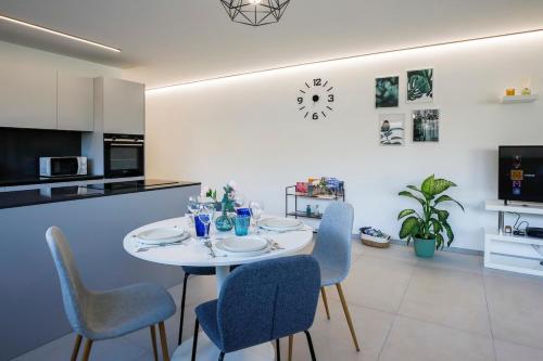 une table et des chaises blanches dans une cuisine avec une table et des chaises dans l'établissement Casa Smeraldo, à Locarno