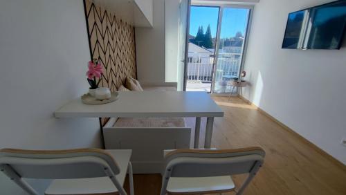 Un comedor con una mesa y dos sillas. en Modern studio in a residence with parking, en Myjava