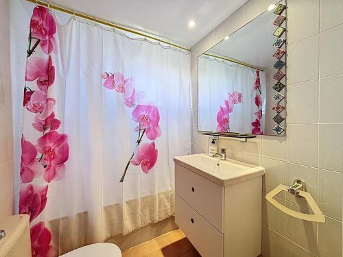 ein Badezimmer mit einem Duschvorhang mit rosa Blumen drauf in der Unterkunft Garbinell A - Piso muy bonito, Vistas al mar espec in Roses