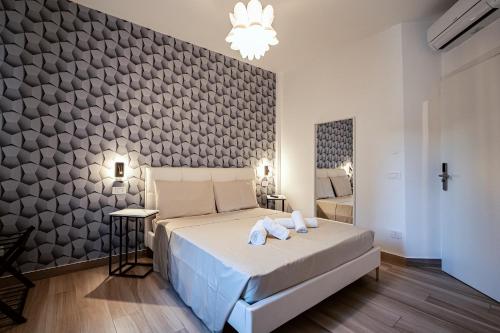 Ein Schlafzimmer mit einem großen Bett und einer gefliesten Wand. in der Unterkunft Colorful Home in Mailand