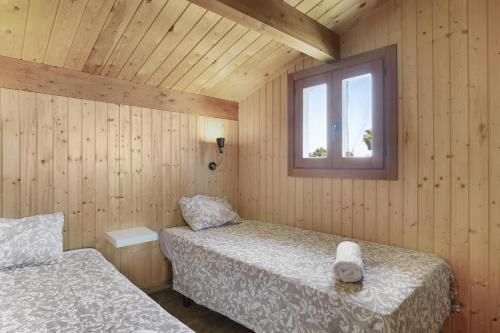 une chambre avec deux lits et une fenêtre dans l'établissement Casa el mirlo, à Conil de la Frontera