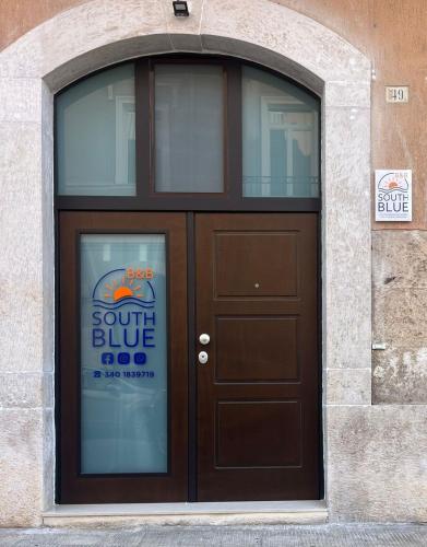 una porta marrone con un cartello sopra di South Blue Apartment a Trani