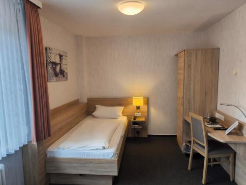 a small room with a bed and a desk and a desk at Hotel und Restaurant Teegen in Leezen