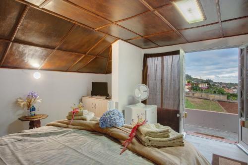 une chambre avec un grand lit avec un plafond en bois dans l'établissement Luci's House, à São Jorge