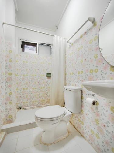 a bathroom with a toilet and a sink and a mirror at Maya Suite in Pratunam