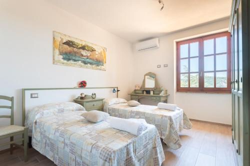 a room with three beds and a window at Meravigliosa Villa In Collina in Scano Montiferro