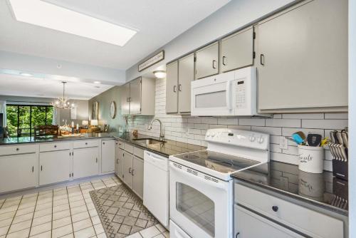 a kitchen with white cabinets and white appliances at Antler Ridge Retreat - 2 BDR in Branson