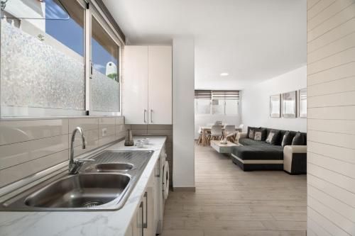 a kitchen with a sink and a living room at Dreams Holidays in Adeje